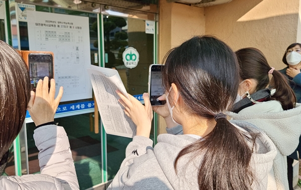 수험생들이 고사장 위치를 촬영하고 있다.