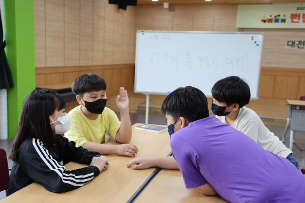 놀이 활동 기획을 위하여 아이디어 회의 중인 아동들