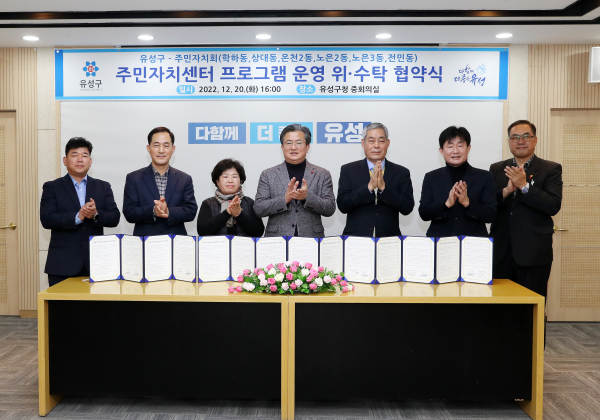 지난 20일 구청 중회의실에서 주민자치센터 프로그램 운영 위․수탁 협약이 체결된 가운데, 참석한 정용래 유성구청장(가운데)과 6개 동 주민자치회 대표들이 기념촬영