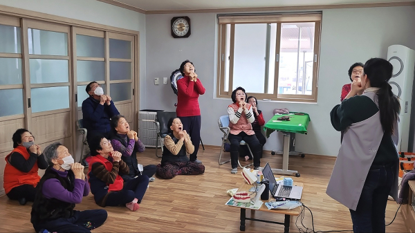 경로당 어르신들이 구강건강교육 프로그램에 참여하는 모습