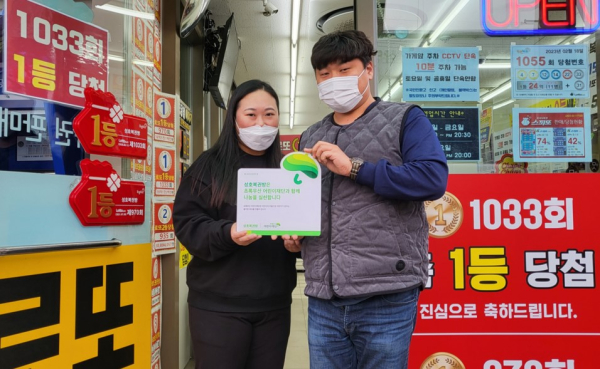 성호복권방 직원들이 나눔현판을 전달받고 인증중이다.