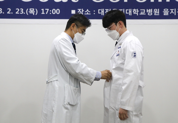 신경과 김재국 교수가 학생에게 착복시켜주는 모습