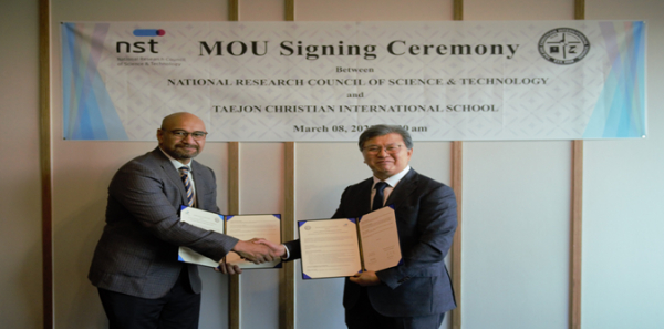 대전외국인학교 모이모이(왼쪽) 총교장과 국가과학기술연구회 김복철 이사장이 업무협약서에 서명한 뒤 악수를 나누고 있다.