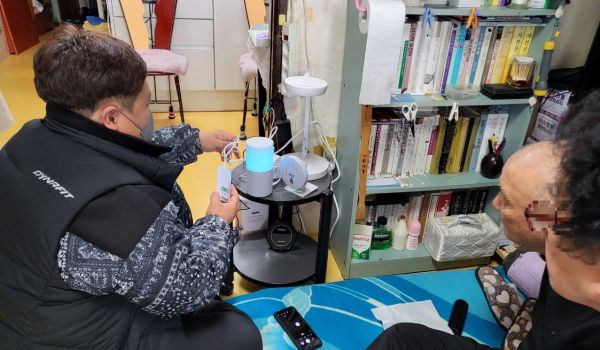 서비스 대상 어르신 댁에 돌봄기기를 설치하고 있는 모습