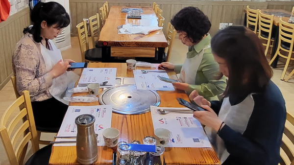 식당 이용객이 식탁보와 부직포 앞치마를 사용하는 모습