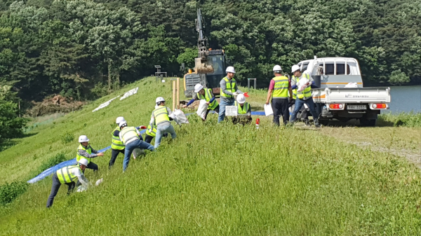 지사 직원들이 저붕괴된 제당 사면 응급복구 작업을 시현하고 있다