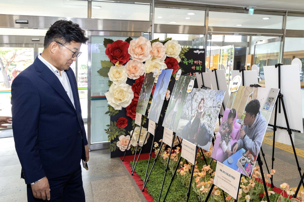 최충규 대덕구청장이 25일 구청 로비에 전시된 ‘육아하는 아빠 사진 공모전’ 수상작을 관람하고 있다