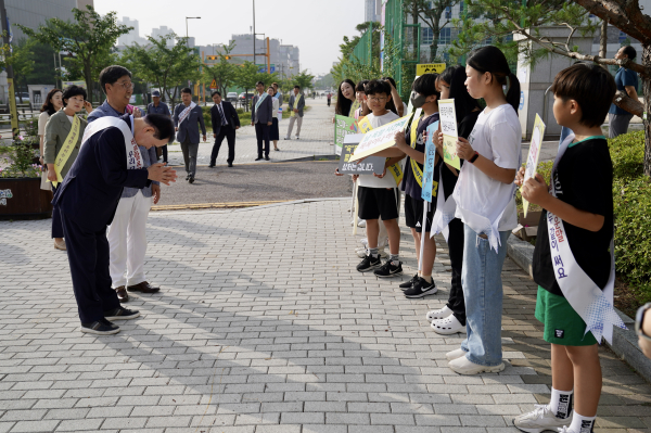 김지철 교육감이 취임 1주년을 맞아 3일 내포초 등굣길에서 따뜻한 말 한마디의 중요성을 강조하며 학생들에게 인사하고 있다.