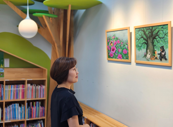 국립대전숲체원 숲속도서실 「열두 달 나무 아이」 원화 전시회를 감상하고 있는 모습.