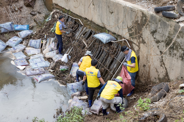 사진은 서부발전 직원들이 하천에 유실된 가축 사료 포대를 수거하는 장면