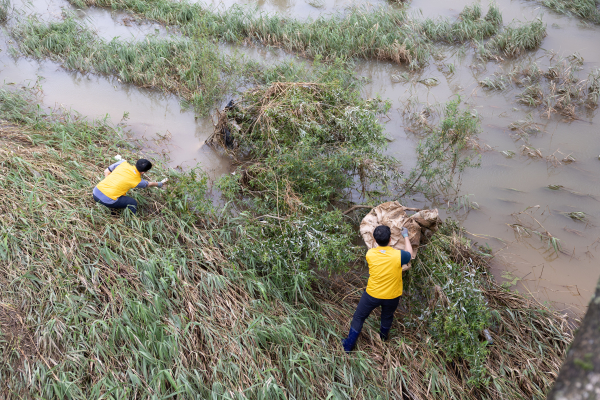 사진은 서부발전 직원들이 하천 범람으로 널브러진 생활 쓰레기를 수거하는 장면