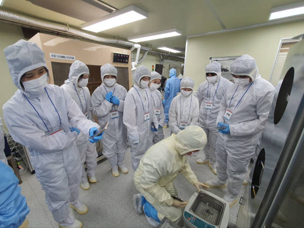 ‘반도체 8대 공정 이해 및 실무교육’ 과정에 참여한 학생들이 반도체 클린룸에서 실습에 앞서 관계자의 설명을 듣고 있다.