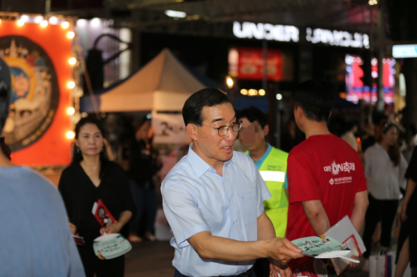 0시 축제장을 찾은 시민들에게 제14회 대전효문화뿌리축제를 병행홍보 중인 김광신 중구청장