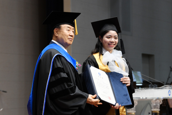 베트남 출신 졸업생 쩐티산 씨(오른쪽)가 백석대 장종현 총장(왼쪽)에게 표창장을 받고 있다.