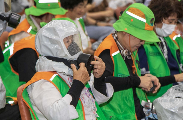 지난 22일 직원 및 주민들이 참여한 가운데 방독면 착용 교육을 진행했다. 지역 주민이 방독면 착용 교육을 듣고 직접 방독면을 착용해보고 있다.