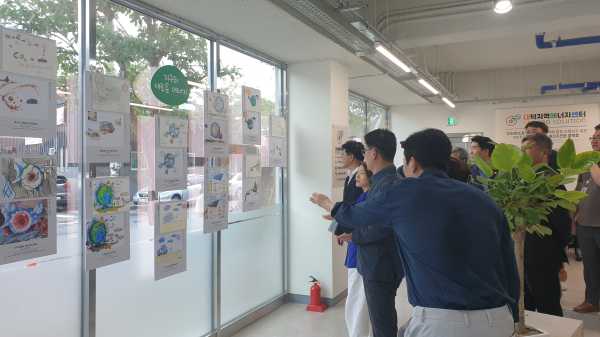 최충규 대덕구청장(사진 왼쪽)이 대덕지역에너지센터를 방문해 과학교육 체험교실(AI&ChatGPT)를 통해 학생들이 창작한 작품을 관람하고 있다