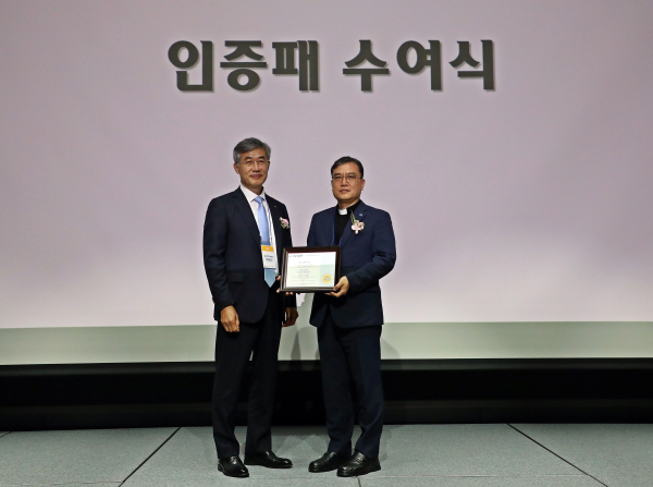 가톨릭대학교 대전성모병원 강전용(사진 오른쪽) 병원장이 가톨릭대학교 성의교정 옴니버스파크에서 열린 ‘AAHRPP 전면인증 획득 기념식’에서 가톨릭중앙의료원 이화성 원장으로부터 AAHRPP 인증패를 전달받고 있다.