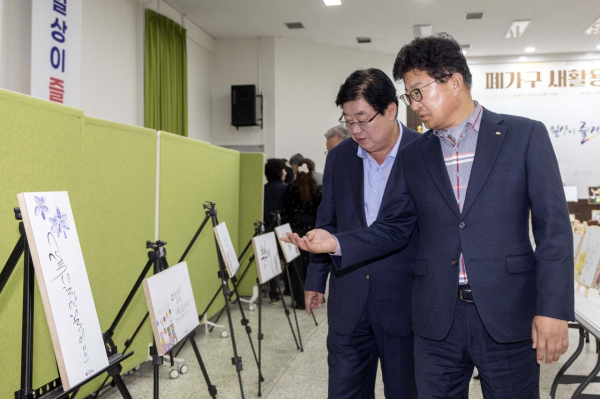 최충규 대덕구청장(사진 오른쪽)이 4일 대덕구청 청렴관에서 열린 ‘2023 자원봉사 리빙랩 성과전시회’에 참석해 전시된 작품들을 관람하고 있다.