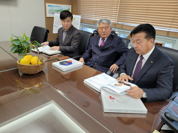 최재구 예산군수와 권오영 능금농협조합장, 이한용 농정유통과장이 예산사과 100년사를 살펴보는 모습