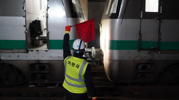 기관사가 열차 간 연결기를 체결하고 있다.