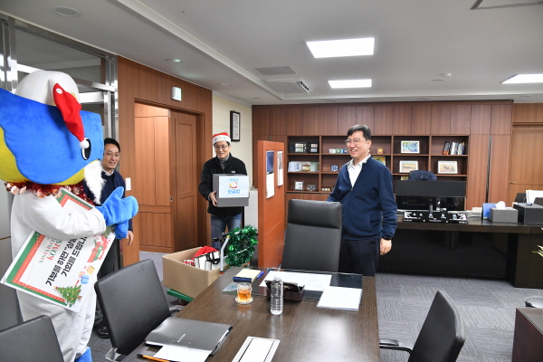 지난 19일 행복한 일터 조성의 일환으로‘깜짝 크리스마스 행사’를 실시했다. 성창훈 조폐공사 사장(오른쪽)이 사장실을 방문한 공사 캐릭터 위보를 따뜻하게 맞이하고 있다