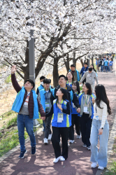 조폐공사 직원과 장애아이가 꽃길을 걷고 있다.