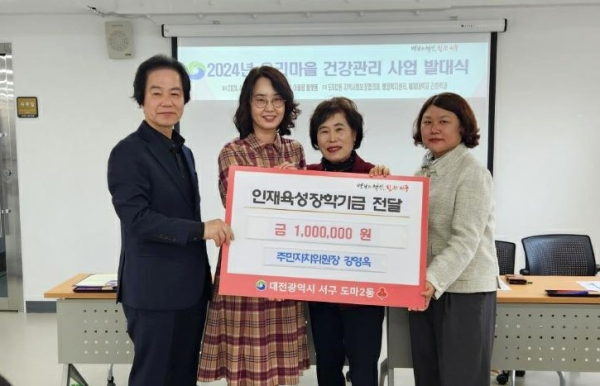 강영옥(오른쪽 둘째) 도마2동 주민자치회장이 안성윤(왼쪽 둘째) 배재대 강호학과 교수에게 12일 인재육성장학기금을 전달하고 있다