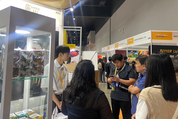 광천우리맛김 부스에서 이종현 학생(국제통상학과 3학년)이 바이어들에게 제품을 설명하고 있다.