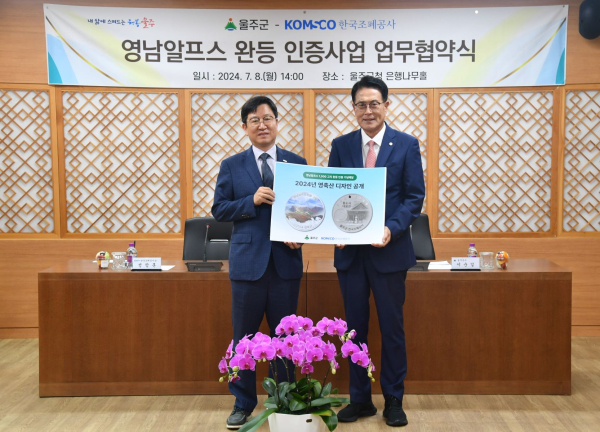 성창훈 사장(왼쪽)과 이순걸 울주군수가 영남알프스 완등 인증 기념메달 사업 업무협약식에서 2024년 영축산 디자인을 공개하고 있다