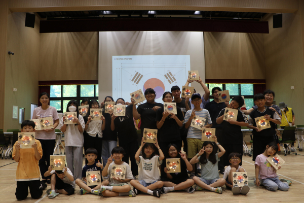 태극기 모양 ‘뚝딱뚝딱 숲울림공방 프로그램’ 결과물을 들고 찍은 단체사진.