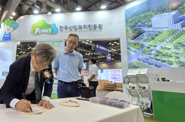 남태헌(왼쪽) 한국산림복지진흥원장이 2024 대한민국 목재산업박람회에 참석하여 홍보부스를 최종 점검하고 있다.