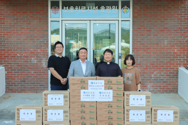 계룡건설 진중길 상무(왼쪽에서 두번째)가 사회복지시설 효광원 김현 원장(왼쪽에서 세 번째)에 위문품을 전달하고 관계자들과 기념 촬영 모습