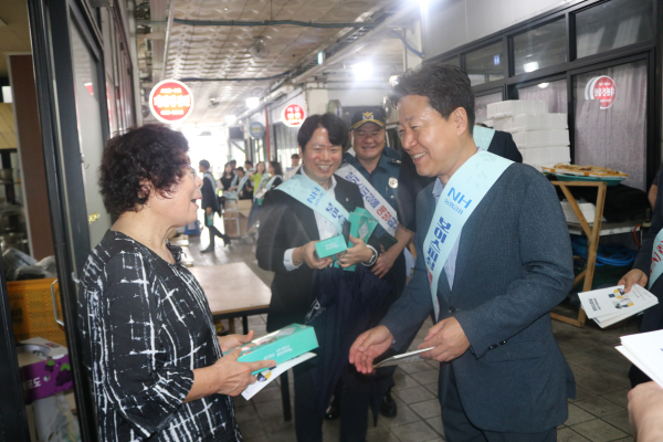 박장순 농협은행 충남본부장이 홍성시장을 찾아 소상공인 금융사기 피해예방을 위한 안내장을 시장상인들에게 나누어주고 있다