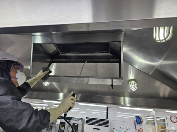 아름초등학교에서 전문 청소 용역 업체 직원이 학교 급식실 환기 시설을 청소하고 있다.