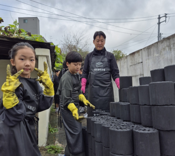 김종문 JM휘트니스 대표와 자녀들이 연탄을 나르기 전 포즈를 취하고 있다.