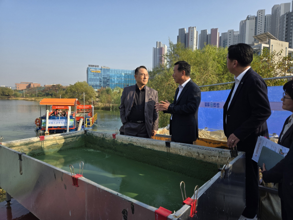 박상돈 천안시장이 성성호수공원에 방문해 육상용 복합공정의 대규모 녹조제거장치에 대한 설명을 듣고 있다.