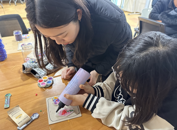 플라스틱 병뚜껑을 재활용해 키링을 만들고 있는 모습