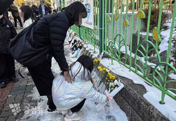 11일 초등생 1학년 여아가 살해당한 대전 서구 한 초등학교 앞에 또래 아이와 어멎니가 추모의 꽃을 놓고 있다 / 이성현 기자