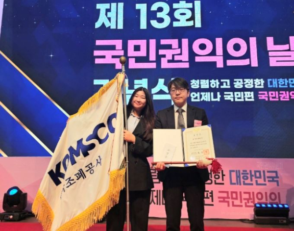 조폐공사 조직법규부 권영규 부장(오른쪽)과 하주영 대리가 국민권익의 날 정부 포상식에서 기념촬영