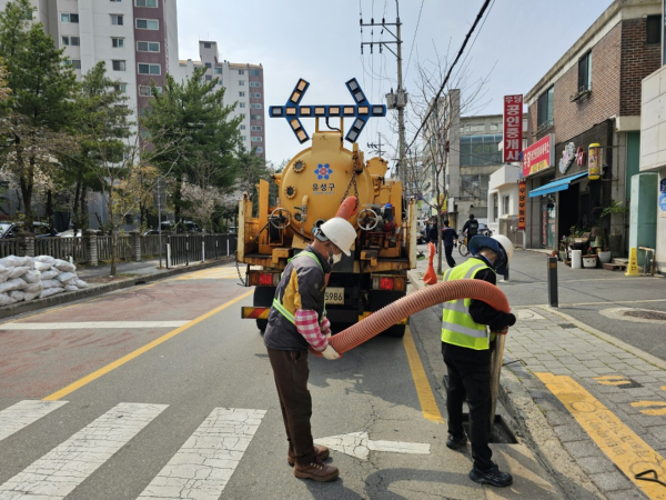 유성구 건설과 직원이 빗물받이 준설 작업을 하고 있다.