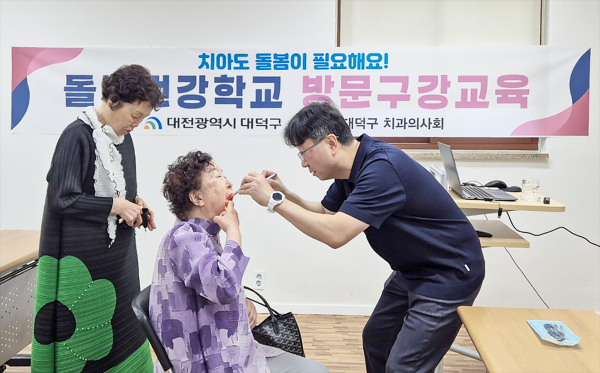 박성환 대덕구 치과의사회 회장이 어르신들의 구강검진을 진행하고 있다.]