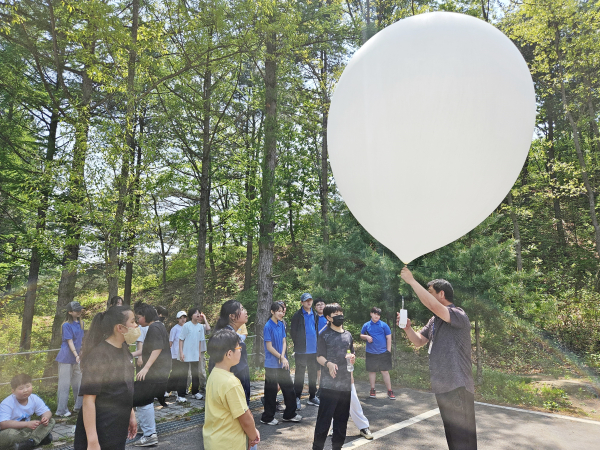 15일 강원도 춘천시 신북읍 국립춘천숲체원에서  춘천서상초등학교 4~6학년 학생들이 기상관측기구(라디오존데)를 부양하기 위해 라디오존데 작동 원리를 듣고 있다.