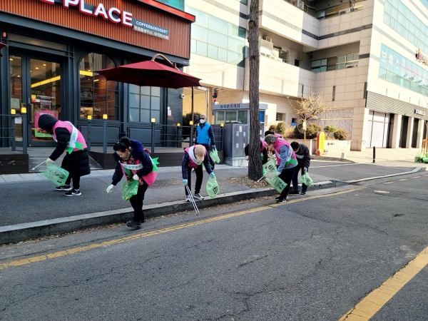 노은3동 직능단체 회원들이 길거리의 쓰레기를 줍고 있다.
