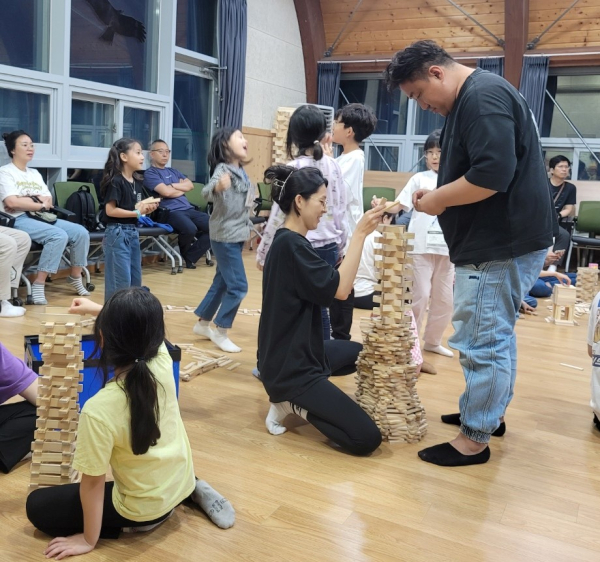 국립예산치유의숲을 찾은 가족들이 ‘편백나무 카프라 쌓기’ 프로그램에 참여하고 있다