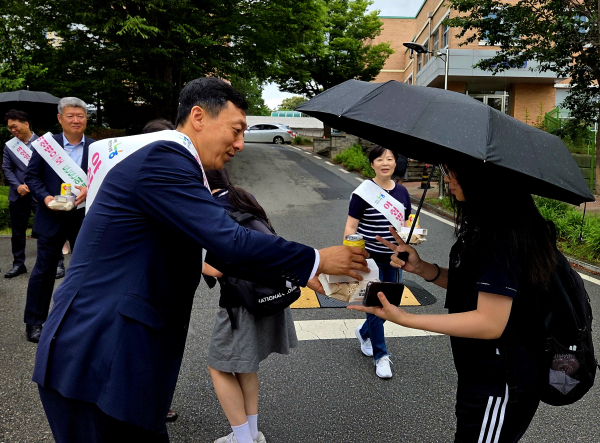 정해웅본부장(왼쪽)이 등교하는 학생에게 떡과 식혜를 나눠주고 있다.