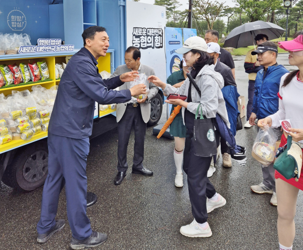 정해웅본부장(왼쪽)이 방문객들에게 밥세트를 나눠주고 있다.
