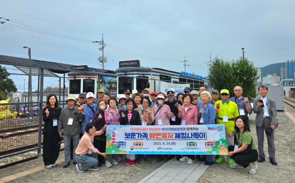 국가철도공단 관계자들과 국가유공자 가족들이 24일 해운대블루라인파크 송정정거장에서 기념촬영