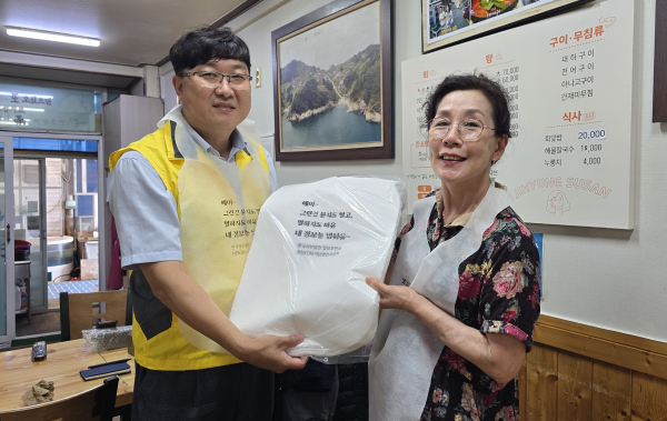 서부발전 관계자들이 태안의 한 음식점을 찾아 정보보호 문구가 새겨진 앞치마를 전달하고 기념촬영하는 모습
