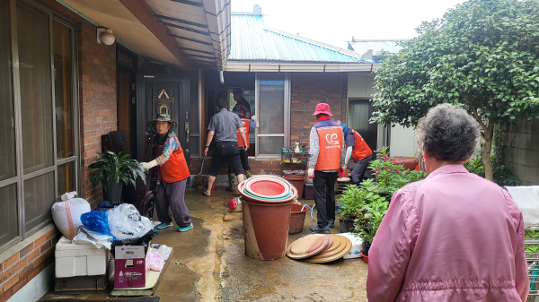 침수 주택의 복구를 위해 가구 정리와 쓰레기 수거에 힘쓰는 자원봉사자 모습