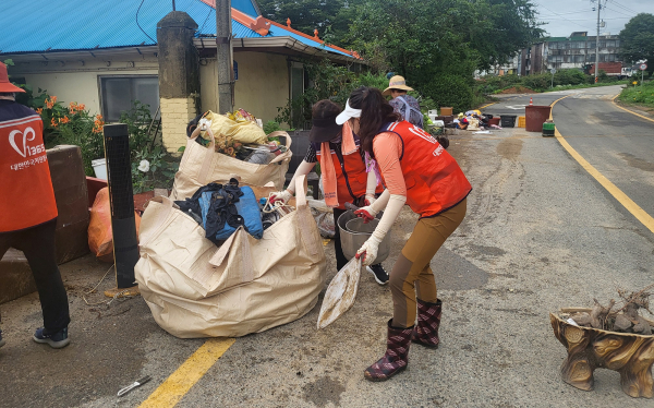 침수 주택의 복구를 위해 가구 정리와 쓰레기 수거에 힘쓰는 자원봉사자 모습